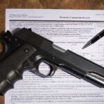 Gun and pen on firearm transaction form.
