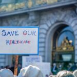 Sign reading "Save Our Healthcare" at protest.