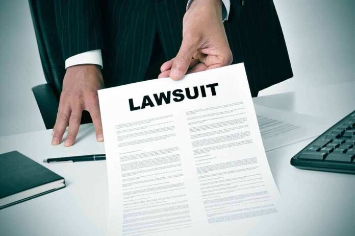 189871757 featured image Person holding a document labeled "Lawsuit."