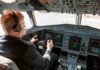Pilot in cockpit operating airplane controls.