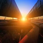 Sunset between two large industrial pipelines outdoors