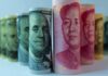 Rolled US dollar and Chinese yuan banknotes.