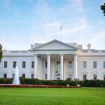 White house with fountain and flags, front view.