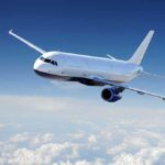 Airplane flying above the clouds in blue sky