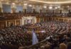 Large audience seated in a formal legislative chamber