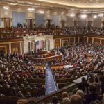 Large audience seated in a formal legislative chamber