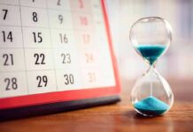 Calendar and hourglass with blue sand