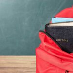 Red backpack with a Bible and books inside