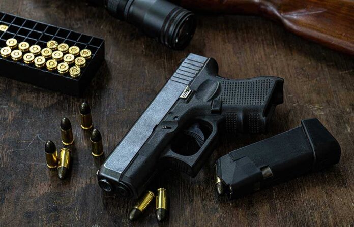 1439841965 featured image Handgun with ammunition magazine and rifle on wooden table