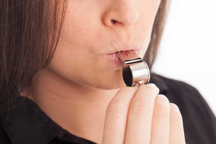 1455310238 featured image Person blowing a silver whistle close up
