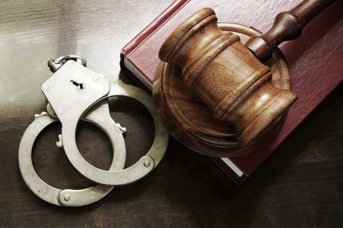 302738369 featured image Handcuffs beside a gavel on a book