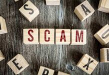 Wooden blocks spell SCAM on a rustic surface