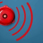 Red alarm bell on a blue background