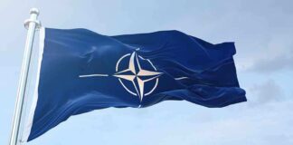 NATO flag waving against blue sky