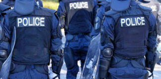 Police officers in riot gear with shields