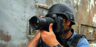 Person in helmet taking photos with a large camera
