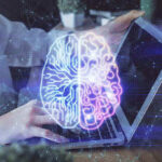 Futuristic AI brain hologram above a laptop computer