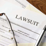 Lawsuit papers with glasses and pen on table
