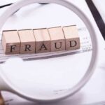 Fraud blocks under magnifying glass on invoices