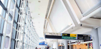 People walking in a brightly lit airport terminal.