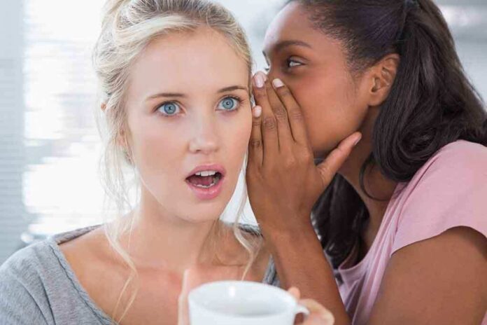 shutterstock_148144184.jpg Two women in a casual setting, one whispering to the other who looks surprised