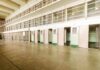 Interior view of a prison cell block with empty cells and security bars
