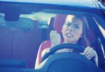 Angry woman gripping the steering wheel in a car
