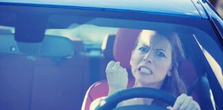 Angry woman gripping the steering wheel in a car