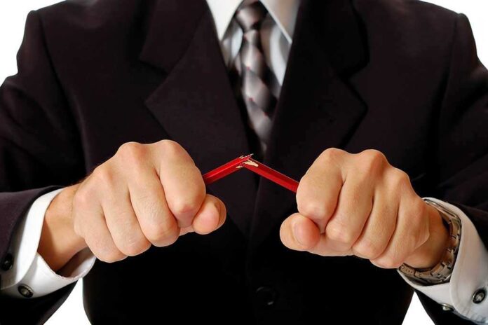shutterstock_59756248.jpg Businessman in a suit breaking a pencil with his hands
