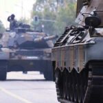 Tanks on a road with soldiers inside