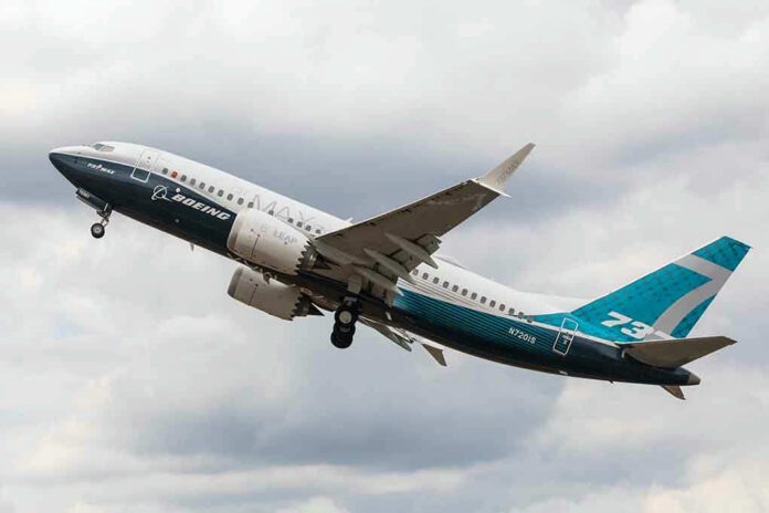 Airplane mid flight against a cloudy sky