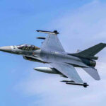 Elite Pilot Lost in Fiery F-16 Crash Jet fighter flying through clear blue sky.