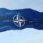 NATO flag waving against blue sky