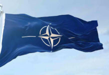 NATO flag waving against blue sky