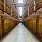 Long hallway with prison cells on both sides