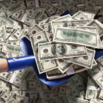 Staggering $825M Missile Deal Shocks U.S. Taxpayers A shovel filled with stacks of cash on a background of scattered dollar bills