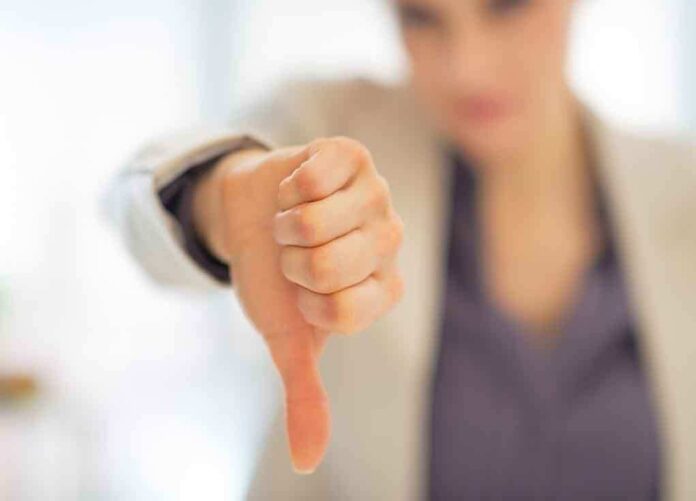 Businesswoman showing a thumbs down gesture in an office setting