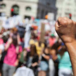 Raised fist in front of a crowd.