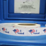 States’s Record Fees CHALLENGED—Legal Showdown Looms Roll of I Voted stickers on table.