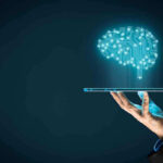 Hand holding tablet projecting digital brain hologram