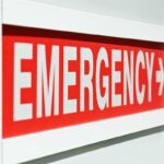 Emergency sign indicating direction with a red background and white text