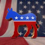 EXPOSED: Democrat Openly Declared Migrants as “Constituents” A donkey symbol representing the Democratic Party in front of an American flag background