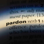 DESPERATE PLEA – Trump Considering Pardon Request! The word pardon highlighted in a dictionary.