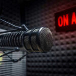 LAWSUIT – Explosive Charges Against High Profile DJ! Microphone in soundproof studio with On Air sign.