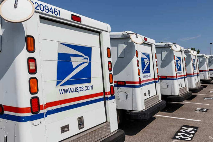 1475396903 Row of USPS mail delivery trucks parked.