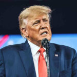 TRUMP FIRES Entire D.C. Department—City Stunned! Man in suit speaking at a podium.