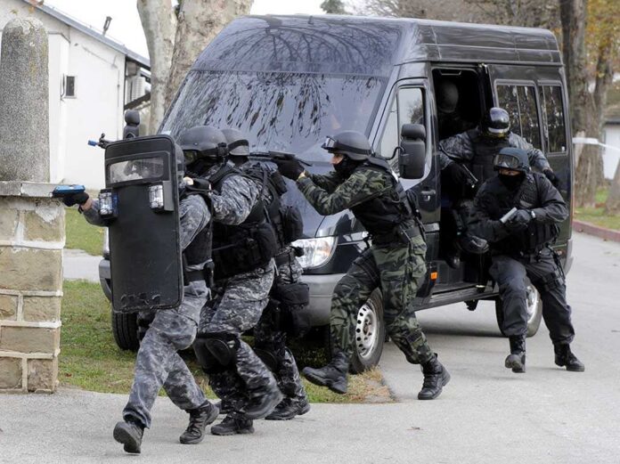 shutterstock_232817302.jpg SWAT team members in tactical gear responding to a situation