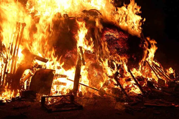 shutterstock_242532967.jpg A large fire engulfing debris at night
