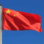 China ATTACKING Christianity – Pastors ARRESTED! Chinese national flag waving against a clear blue sky