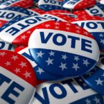 HUGE Candidate Endorsement Stuns Race! A pile of colorful buttons with the word VOTE and stars, symbolizing election participation